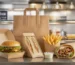 Boîte burger, étui sandwich, emballage kebab, cornet de frites et sac kraft sur le passe d’un fast-food.